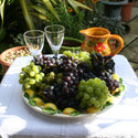bowl on a table with boskoop grapes with wine glasses and a jug